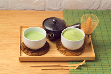 Matcha green organic tea cup and powder on wooden table