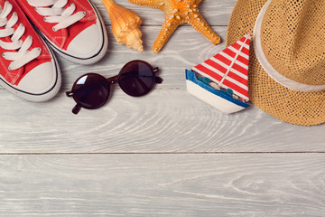 Wall Mural - Summer vacation background with shoes, sunglasses and hat on wooden board. View from above