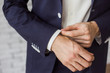 © Andrii Oleksiienko - Closeup of elegant young fashion man dressing up for wedding celebration. Color close up image of male hands. Handsome groom dressed in modern blue formal suit, white shirt getting ready for event.