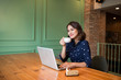 © makistock - Beautiful cute asian young businesswoman in the cafe, using laptop and drinking coffee smiling