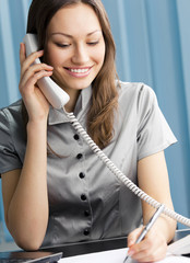 Wall Mural - Young business woman with phone at office