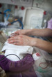 © RF BSIP - Close-up of nurse attaching electrodes to baby's scalp in incubator