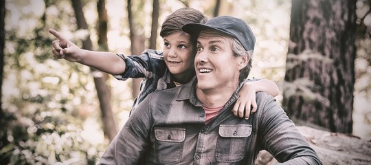 Curious boy showing something to father in forest