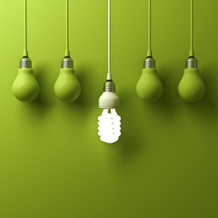 Fototapete - One hanging energy saving light bulb glowing different standing out from unlit incandescent bulbs with reflection on green background, leadership and different creative idea concept. 3D rendering.