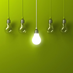 Fototapete - One hanging light bulb glowing different and standing out from unlit incandescent bulbs with reflection on green background , leadership and different business creative idea concept . 3D rendering.