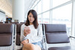 © leungchopan - Woman use of mobile phone in airport