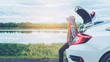 © joyfotoliakid - Relaxed happy woman traveler on summer roadtrip vacation on hatchback car