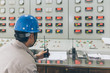 © fanjianhua - workers using walkie-talkie in control room of a factory.