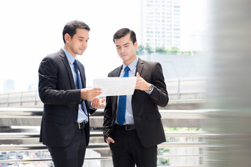 Wall Mural - Businessmen as colleague discussing document outdoor