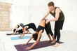 © Drobot Dean - Male yoga trainer helping a woman to do yoga stretches