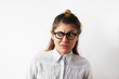 © shurkin_son - Portrait of skeptical Caucasian young entrepreneur female wearing white stripped shirt and eyeglasses looking aside with raised eyebrow. Young business woman with disgust and disapproval on her face