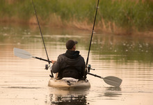 Fisherman In Inflatable Canoe.