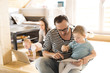 © Halfpoint - Young parents with little children and gadgets at home.