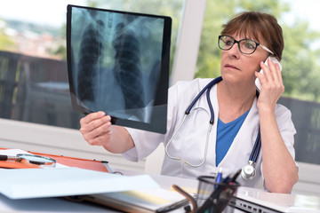 Wall Mural - Female doctor examining x-ray report