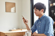 © one - カフェで携帯電話を使う男性
