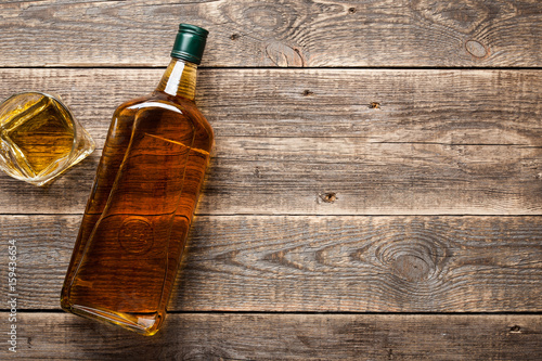 Cuadros en Lienzo Bottle and glass of whiskey on wooden boards