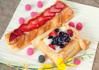 Wall Mural - Pastries with berries on a wooden background. Summer fruit dessert