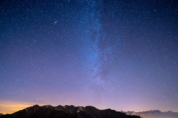 Wall Mural - the wonderful starry sky on christmas time and the majestic high mountain range of the italian frenc