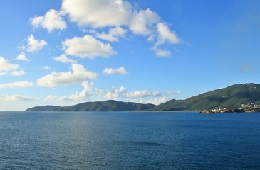 Wall Mural - Ocean and mountain landscape with blue sky and white clouds