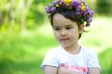 Wall Mural - Portrait of a cheerful girl with a wreath of flowers on her head