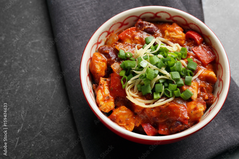 Bowl with delicious chili turkey on table
