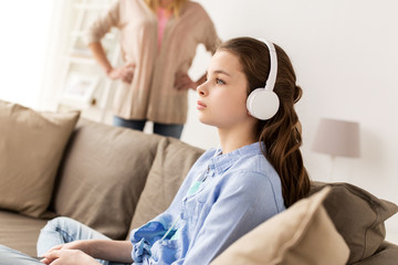 Canvas Print - girl with earphones and angry mother at home