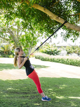Young Woman Training With Resistance Band Outdoors