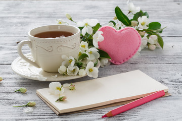 Love card in summer bouquet of gentle blooming apple and tea in china teacup