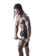 © starsstudio - Handsome shirtless African man applying massager on his leg isolated on white.