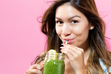 Happy young woman drinking smoothie