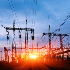 Wall Mural - distribution electric substation with power lines and transformers, at sunset.