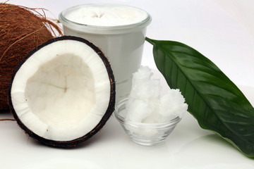 Wall Mural - Coconut with leaves and coconut oil in jar on wooden background