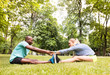 © Halfpoint - Running couple stretching and warming up in park before training