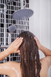 © geargodz - woman is washing her hair and face by rain shower, rear view