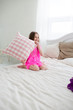 © jyliagorbacheva - Pretty girl in pink dress in bed with cushin