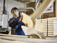 Woman Examining Wood Plank In Printing Workshop