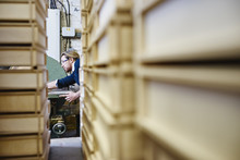 Young Man Between Stacks Of Letterpress Trays In Traditional Print Workshop