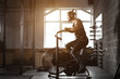 young man using exercise bike at the gym. Fitness male using air bike for cardio workout at crossfit gym.
