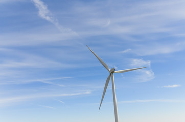 Wall Mural - Low angle, close-up view a wind turbine tower again cloud blue sky on a wind farm at Ellensburg, Washington, US. Clean, sustainable, renewable energy concept. Alternative energy source from wind power