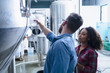 © Connect Images - Colleagues in brewery discussing fermentation tank