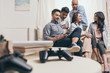 © LIGHTFIELD STUDIOS - young casual multiethnic friends spending time together while sitting on sofa at home