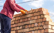 © schankz - Worker builds a brick wall in the house