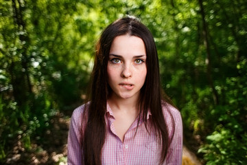 Wall Mural - Portrait of timid, shy cute young woman biting lips