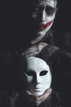 Sad Clown Holds White Mask