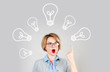 Beautiful business woman has an idea showing finger up on light bulb over her head. Brainstorm. Decision making concept 