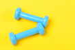 © be free - Dumbbells in blue color isolated on bright yellow background