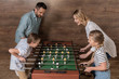© LIGHTFIELD STUDIOS - Happy smiling family playing foosball together