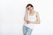 © sergeyzapotylok - Young beautiful brunette beginner model woman in white t-shirt blue jeans practicing posing showing emotions on white wall studio background