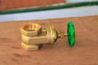 © pramot48 - brass valve with green knob in a factory plumber. on wooden floor background