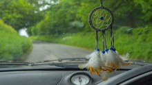 Dream Catcher Hanging In Car Driving Down Road
